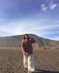 Full length of girl standing in desert against sky