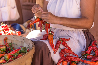 Close-up of man holding red chili peppers at market