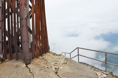 Close-up of railing by sea against sky