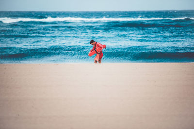 Woman standing on beach against sea