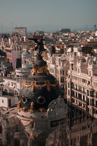 Statue in city against clear sky