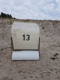 Text on sand at beach against sky