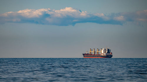 Boat sailing in sea against sky