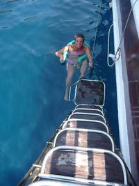 High angle portrait of smiling young woman in sea