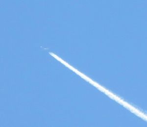 Low angle view of vapor trails in blue sky