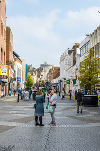 People on street in city against sky