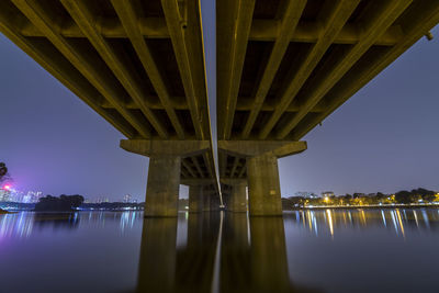 Bridge over river against sky at night