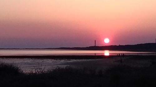 Scenic view of beach against sky during sunset