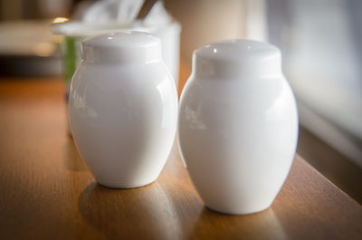 Close-up of salt and pepper shakers on table at home