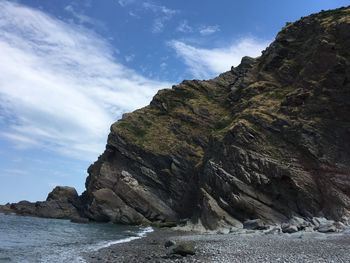 Rock formations by sea against sky