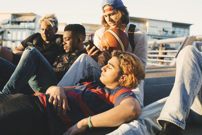 Rear view of two people sitting on floor