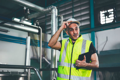 Engineer looking away at factory