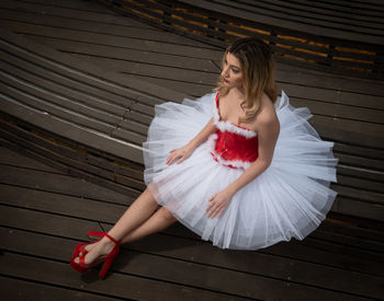 Ballerina wearing christmas white red dress posing on the floor