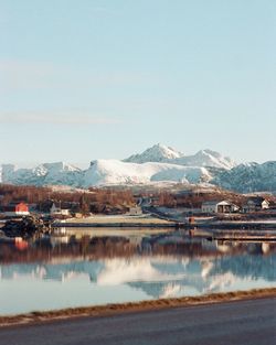 Scenic view of lake by snowcapped mountains against sky