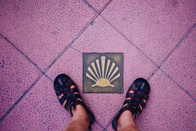 Low section of man standing on tiled floor