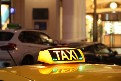 Close-up of illuminated information sign on car at night