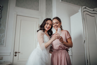 Bridesmaid and bride holding champagne flute