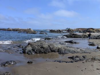 Scenic view of rocky beach against sky