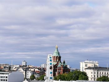 View of cityscape against cloudy sky