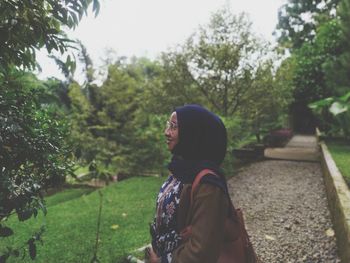 Side view of woman in hijab standing at park