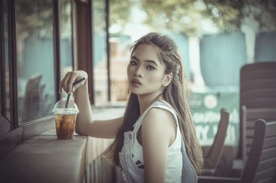 Portrait of young woman sitting outdoors