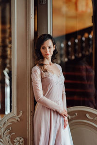 Portrait of woman standing against wall