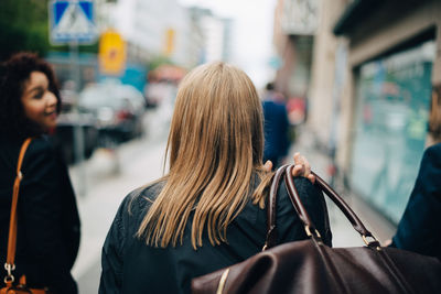 Rear view of women standing at store