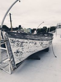 Abandoned boats moored on beach against sky
