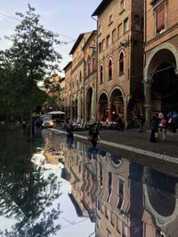 Group of people in canal against buildings in city