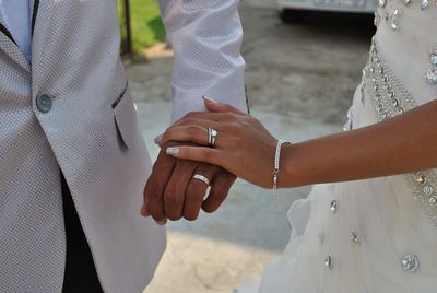 Midsection of bride holding wedding dress