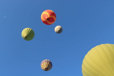 Low angle view of hot air balloons against blue sky