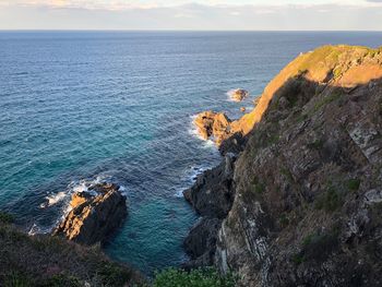 Rock formations in sea against sky