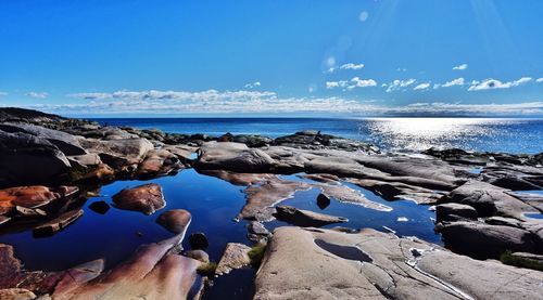 Rocks on beach against blue sky