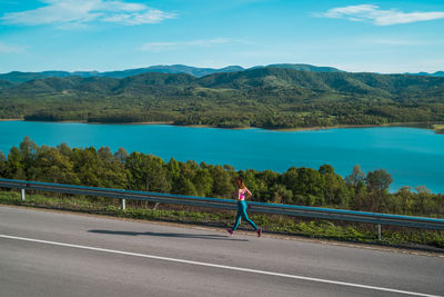 Man riding bicycle on road against sky