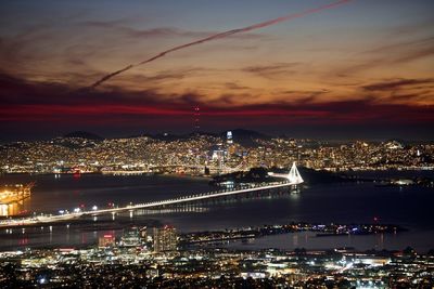 Illuminated cityscape against sky at night