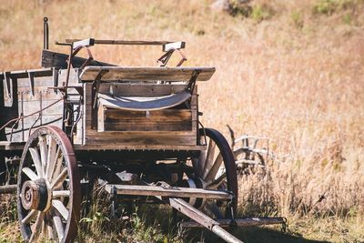 Old abandoned horse cart on grassy field