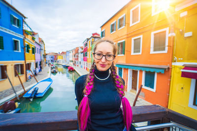 Portrait of young woman standing in city