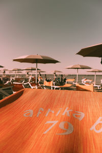 Chairs and parasols on beach against clear sky