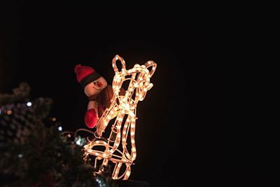 Low angle view of illuminated lighting equipment at night