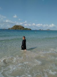 Man in sea against sky