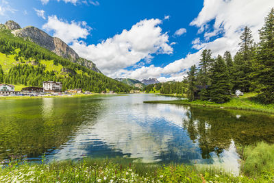 Scenic view of lake by trees against sky