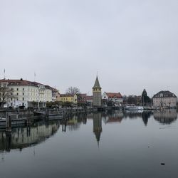 Reflection of buildings in river against sky