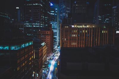 Light trails on street amidst buildings in city at night