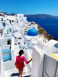 Rear view of woman standing by sea in oia, santorini