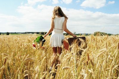 Woman walking on field against sky