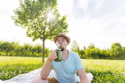 Young man holding food on field