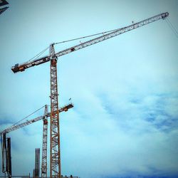 Low angle view of crane against sky