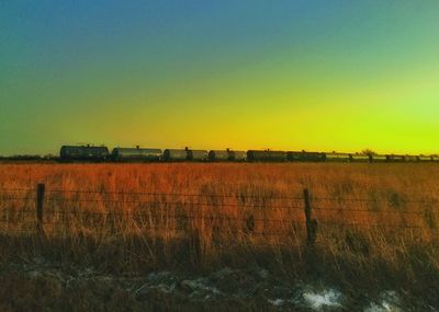 Scenic view of field against sky at sunset