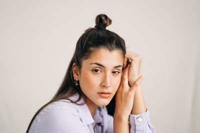 Portrait of young woman against white background