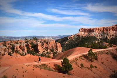 Rock formations on landscape against cloudy sky